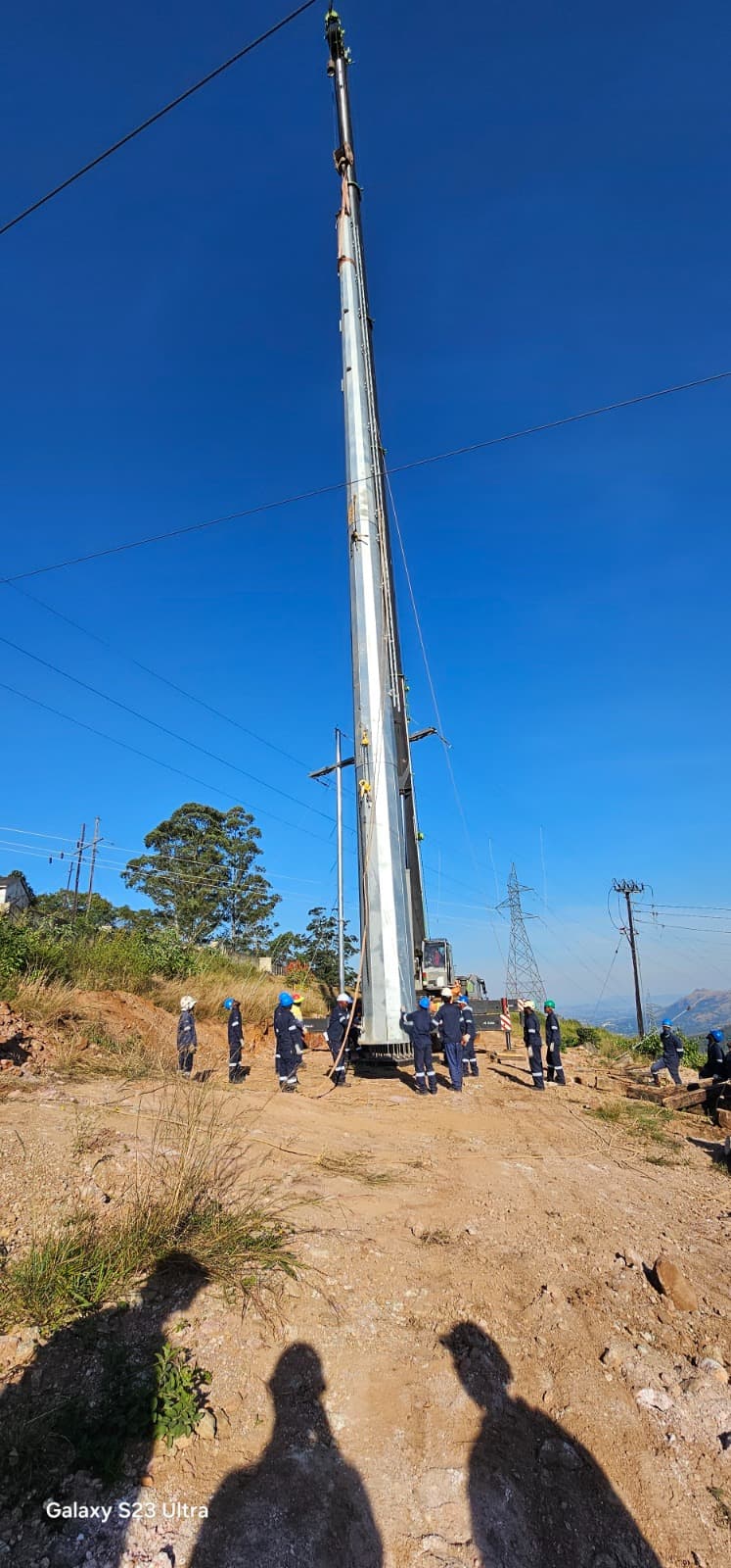 ELTEK crew erecting a power line on a hillside